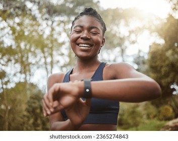 African runner woman, smart watch and park for check, smile or happy for time, results or fitness in nature. Girl, iot clock and monitor for speed, heart rate or smile for exercise, workout or health - Powered by Shutterstock