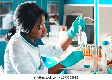 Afrikanischer Wissenschaftler oder Student mit Abschluss in Labormantel und Schutzkleidung führt PCR-Tests von Patientenproben im modernen Testlabor durch. Fehlerbehebung bei PCR-Kits zur Diagnose von Covid-19-Patienten.