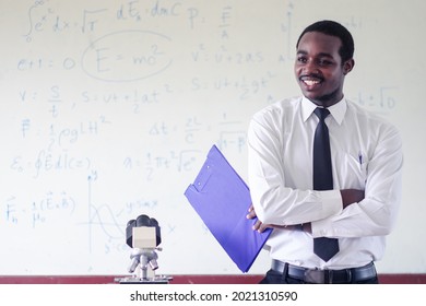 African scientist teacher is teaching science classes with using microscope in the classroom.Concept of Happy teacher`s day