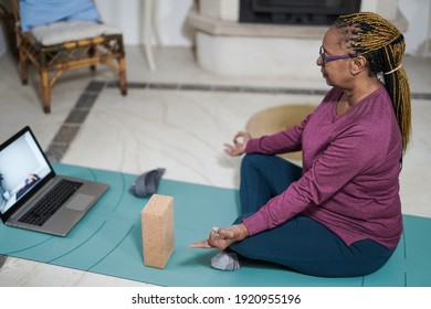 African Senior Woman Doing Meditation With Laptop At Home Indoors