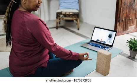 African Senior Woman Doing Online Yoga Lesson At Home During Coronavirus Outbreak - Focus On Hand