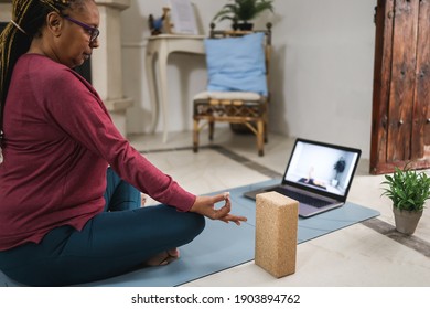 African Senior Woman Doing Online Yoga Lesson At Home - Focus On Hand