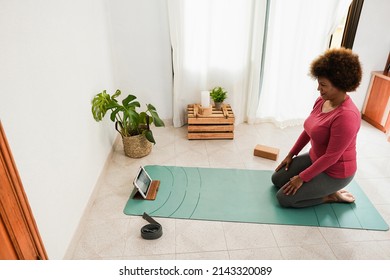 African Senior Woman Doing Online Yoga Class At Home - Focus On Face