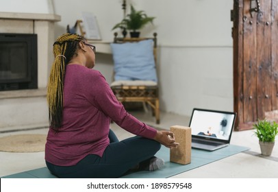 African Senior Woman Doing Yoga Virtual Fitness Class With Laptop At Home - E-learning And People Wellness Lifestyle Concept