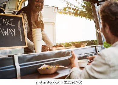 African Senior Woman Serving Take Away Food Inside Food Truck - Focus On Cutting Board