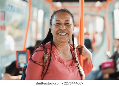 African senior woman smiling on camera inside tram - Transportation, travel and elderly lifestyle concept  - Powered by Shutterstock