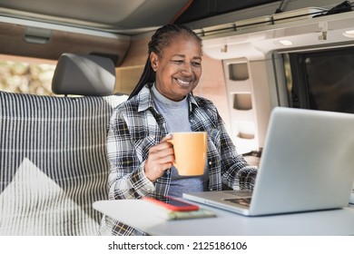 African Senior Woman Using Computer Laptop Inside Mini Van Camper