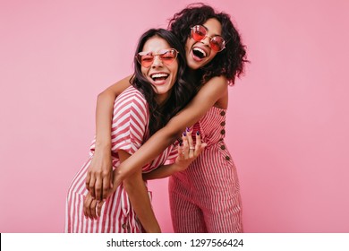 African sisters with dark curls are having fun in wonderful mood. Portrait of embracing girls with beautiful appearance - Powered by Shutterstock