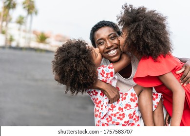 African sisters twins kissing mother on the beach - Black family having fun outdoor during summer vacation - Love, real people and travel concept - Main focus on mum face
