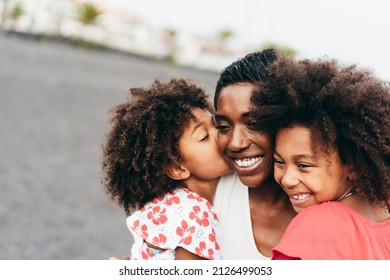 African sisters twins kissing mother on the beach - Main focus on mum nose