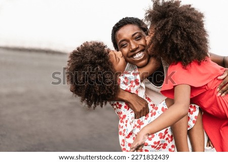 African sisters twins kissing mother on the beach - Focus on mom face