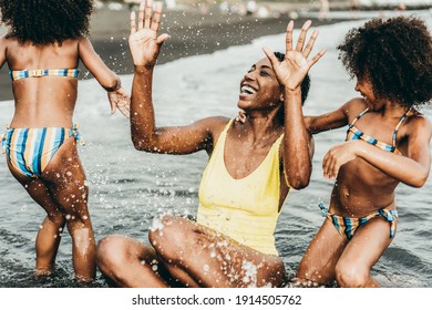 African Sisters Twins Playing On The Beach With Smiling Mother - Black Family People Having Fun On Summer Time - Main Focus On Mum Face