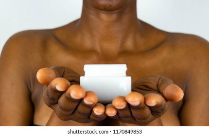 African Skin Care. African American Woman Taking Care Of Her Dry Brown Skin Complexion. Moisturizing Cream In Black Female Hands Isolated. Beauty Treatment.