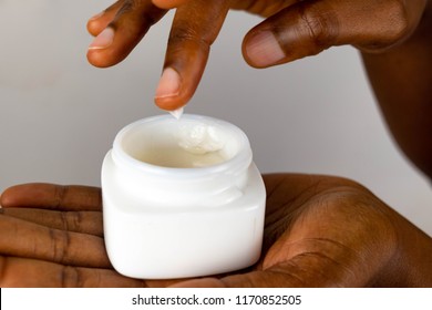 African Skin Care. African American Woman Taking Care Of Her Dry Brown Skin Complexion. Moisturizing Cream In Black Female Hands Isolated. Beauty And Anti-aging  Treatment .