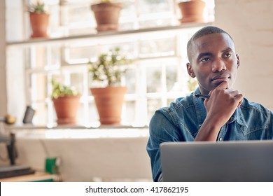 African Small Business Owner With His Laptop Looking Away Though