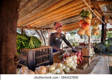 african street vendor, selling onions, cabbage, tomatoes.