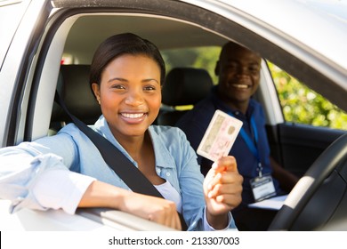 african student driver passes driving test and holding her driver's license