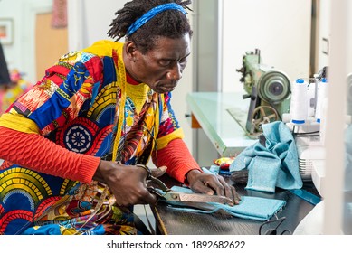 afrikanischer Schneider aus dem Senegal bei der Arbeit in seinem Workshop, handgefertigte Herstellung von europäischen Modebekleidung mit afrikanischem Wachs, Konzept der Vielfalt und Integration, neue kleine Sozialunternehmen