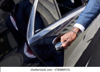 African Taxi Driver Opening The Door Of Car, Help Female Client To Get Out Of Car. In Luxurious Executive Car, Business Lady