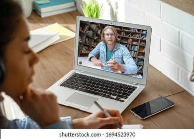 African teen girl college student, school pupil wears headphones distance learning from home on video conference call, web cam chat with online teacher tutor remote lesson on computer screen, closeup. - Shutterstock ID 1694523970