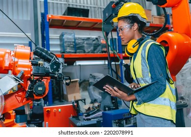 African Teen Young Smart Women Engineer Worker Working In Advanced Robotic Factory With Safety