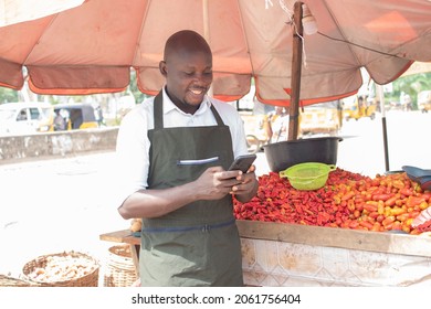 An African Trader Looking At His Smartphone