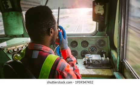 African Train Driver Talking Radio Communication Or Walkie Talkie In  Interior Room To Control Place Of Train