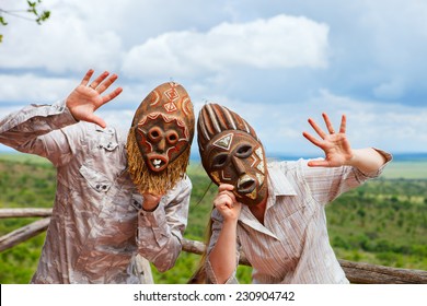 African Vacation. Happy Couple In African Masks At Balcony In Safari Lodge.