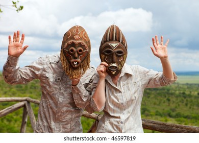 African Vacation. Happy Couple In African Masks At Balcony In Safari Lodge.