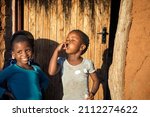 African village two happy children playing in the yard in front of the house