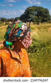 African Village Woman Wearing A Mask And Colorful Scarf 