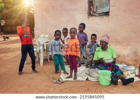 african villagers granny with grandchildren standing in the yard