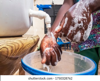 An African washing hands under running water from for protection.
