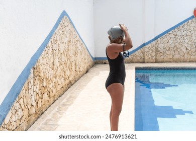 African Woman Adjusting Swim Cap by the Pool - Powered by Shutterstock