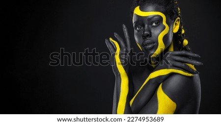African woman with art fashion makeup. Download high resolution Picture with black and yellow body paint on african woman for your Music track or website design. Create album cover with creative Image