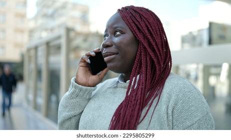 African woman with braided hair speaking on the phone at street - Shutterstock ID 2295805299
