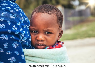 African Woman Carry Her Child Wrapped In A Towel In Her Back In A Traditional Way