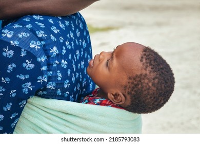 African Woman Carry Her Child Wrapped In A Towel In Her Back In A Traditional Way, 