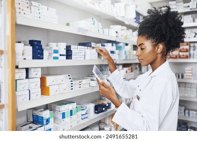 African woman, check or tablet with screen in pharmacy for stock inspection, report for medicine inventory. Female pharmacist, drug store or ebook for digital record of health information or research - Powered by Shutterstock