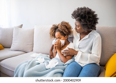 African Woman Checking Temperature With Hand Of Little Ill Daughter. Mother Checking Temperature Of Her Sick Indian Girl. Sick Child Lying On Bed Under Blanket With Woman Checking Fever On Forehead