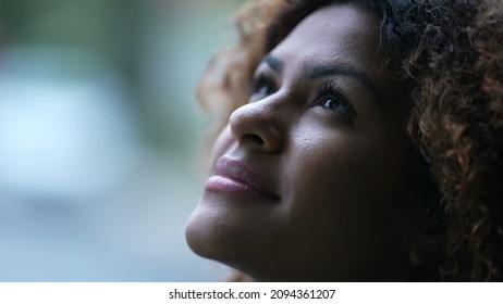 African woman close-up face looking at sky smiling in contemplation - Powered by Shutterstock