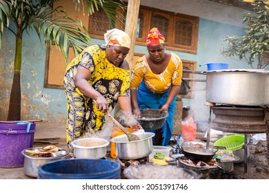 African woman cooking traditional food at street