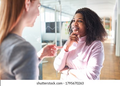 African Woman In Dialogue Or Small Talk With A Colleague In The Office