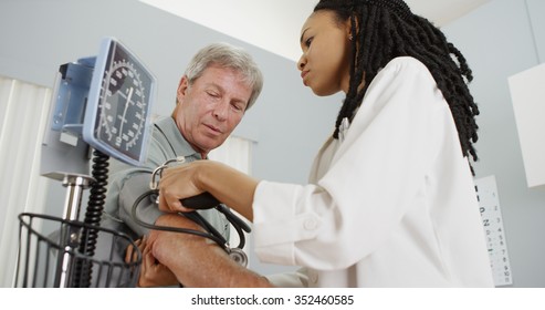 African Woman Doctor Checking Patient's Blood Pressure