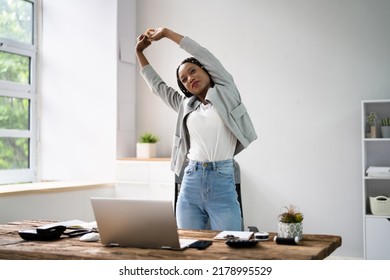 African Woman Doing Stretching Exercise At Office Desk - Powered by Shutterstock