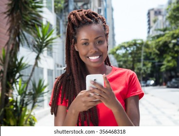 African woman with dreadlocks sending message in the city - Powered by Shutterstock