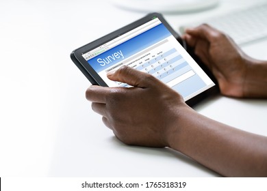 African Woman Filling Survey Poll Or Form On Tablet Computer