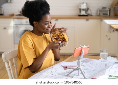 African Woman Food Blogger Create New Content While Eating Pasta At Home Kitchen. Young Afro Female Record Vlog On Smartphone Or Make Video Call To Friends Or Family At Break From Study Or Remote Work