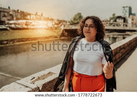 African woman glasses and modern clothes combination posing in modern city