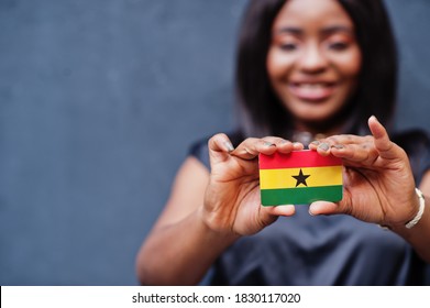 African Woman Hold Small Ghana Flag In Hands.